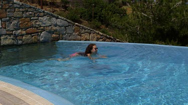 Teenage Girl Swimming In Infinity Pool, Elounda, Crete, Greece