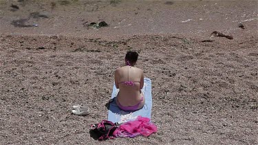 Woman Throwing Pebbles In Sea, Balaklava, Criema, Ukraine