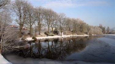 Man Walks Dog At Frozen Small Lake, Weaponness Valley, Mere, Scarborough, England