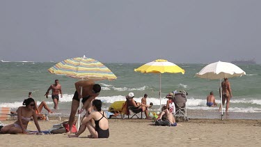 Man Adjusts Parasol On Beach, Lido, Venice, Italy