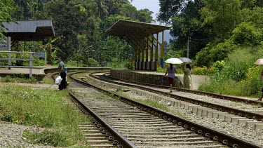 People Cross Railway Tracks With Umbrellas, Peradeniya, Sri Lanka