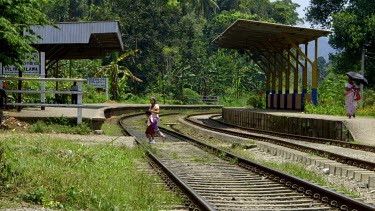 People Cross Railway Tracks With Umbrellas, Peradeniya, Sri Lanka