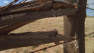 perspective along fence to mountains in desert background