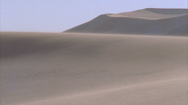 wind blowing sand down sand dune