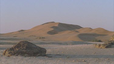 sand dunes with grass blowing in wind in foreground