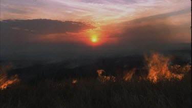 fire rages, sunset in background