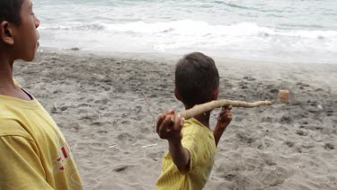 Children practicing harpooning on a beach