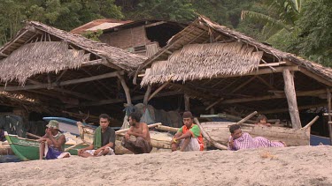 Lembata villagers and boat sheds on the beach in Lamalera whaling village