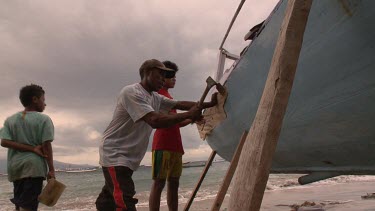Repairing a boat on shore