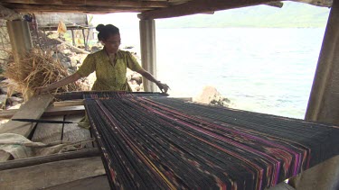 Woman weaving in a hut