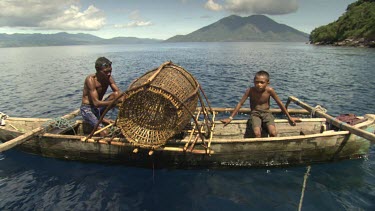 Locals with a large fish trap on a canoe