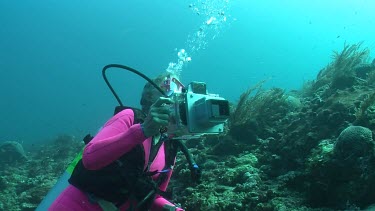 Scuba diver photographing on a reef