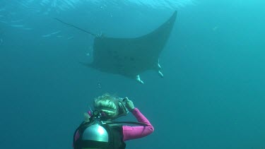Scuba diver photographing a Manta Ray swimming underwater