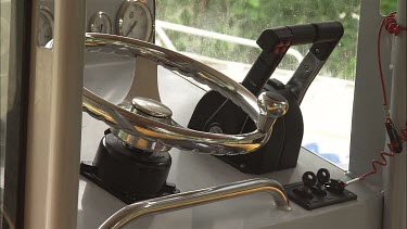 Close up of the steering wheel and throttle of a boat