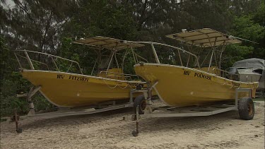 Pair of small yellow boats on trailers