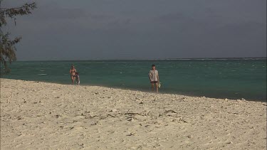 Tourists walking along the beach