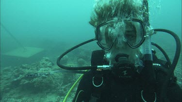 Close up of Diver's face and then he swims away
