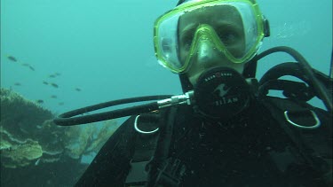 Research diver underwater looks at the coral