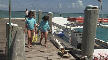 Two girls on the warf going for a diving.
