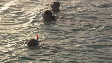 Three girls are snorkeling.