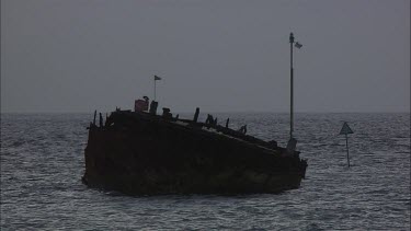 Ruins of the ship. Expedition boat goes. Night time.