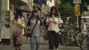 Pedestrians walking on a busy city sidewalk