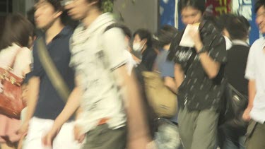 Pedestrians walking on a busy city sidewalk