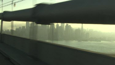 Driving on a bridge into a hazy city at sunrise