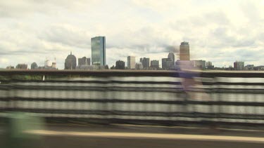 Driving on a bridge past a city