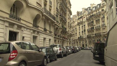 Cars parked on an old, narrow city street