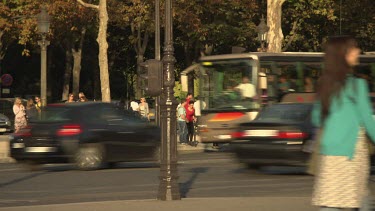 Traffic and a pedestrian on a busy city street