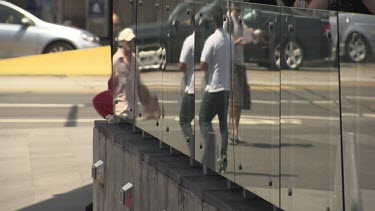 Pedestrians walking by a reflective surface
