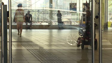 Visitors walking in a glass building