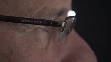 Close up of a man wearing glasses looking at a computer screen