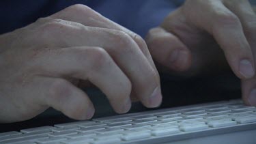 Close up of a person typing on a keyboard
