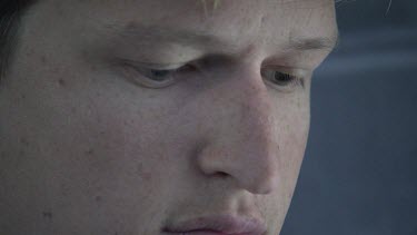 Close up of a man looking at his hands as he types on a keyboard