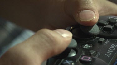 Close up of a person playing on a Playstation controller