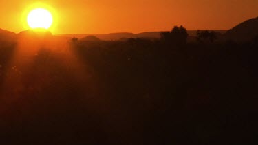 Orange sunset over silhouetted mountains