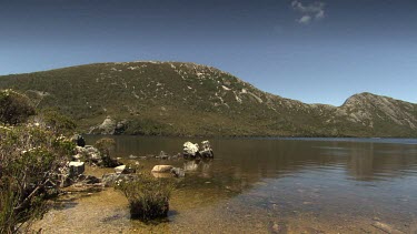 Rocky mountains and a wooden shelter at the edge of a lake