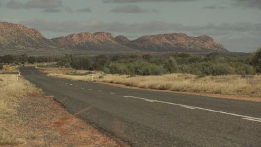 Road and mountain landscape under a cloudy sky