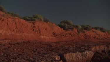 Gentle waves on a dry red coast