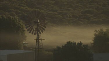 Morning fog over a small village and dense vegetation