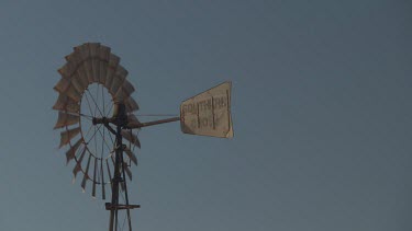 Decorative windmill and sign against a blue sky