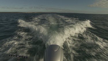 Spray and waves behind a motorboat