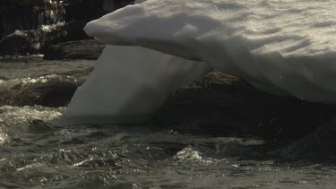 Patch of snow over a flowing stream