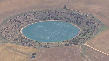 Bright blue lagoon surrounded by dry scrub vegetation