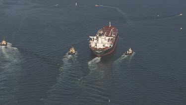 Freight boat flanked by smaller boats
