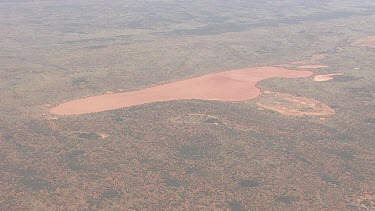 Large sandbar surrounded by forest in the outback