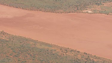 Large sandbar surrounded by forest in the outback
