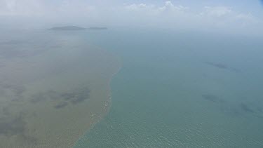 Aerial view of vegetation in the deep, cloudy ocean in Daintree National Park